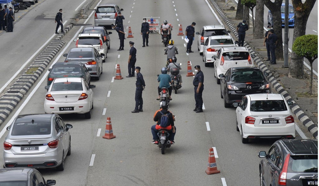 Police officers check vehicles at roadblock to ensure that people abide by the movement control order in downtown Kuala Lumpur. Photo: AP