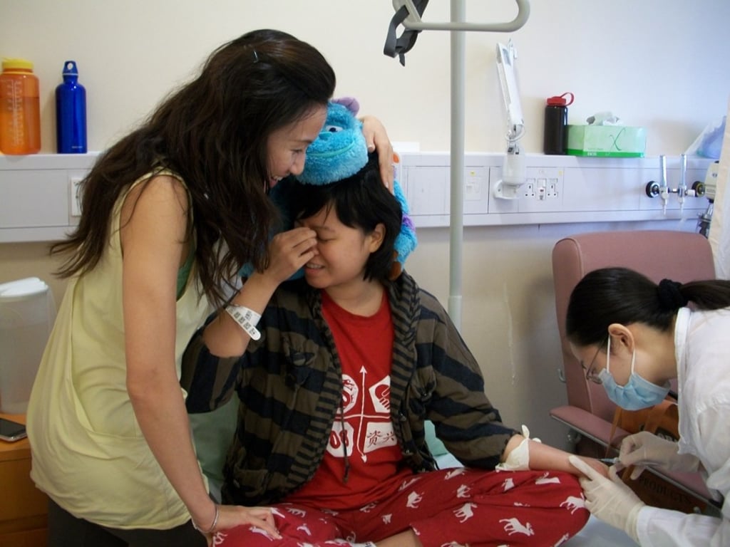 Tam (centre) is comforted by her sister at a hospital in Hong Kong in February 2010, during a stressful period of her cancer treatment. Photo: Denise Tam