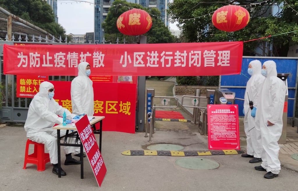 Workers enforcing a quarantine at a residential compound in Wuhan in Hubei province on February 13, 2020. While epidemiologists scrambled to find the cause and transmission path of the virus, authorities resorted to the most primitive measure to contain its spread, locking an estimated 50 million people under quarantine. Photo: China Daily via REUTERS