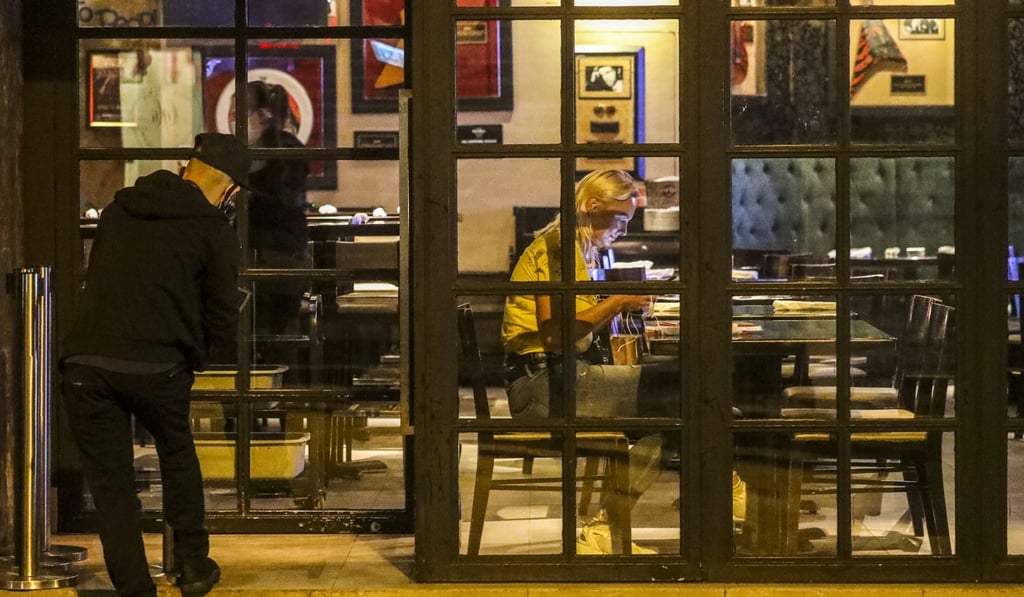 A woman sits inside an almost empty restaurant in Lan Kwai Fong, a popular nightlife area in Central, Hong Kong. Photo: Dickson Lee