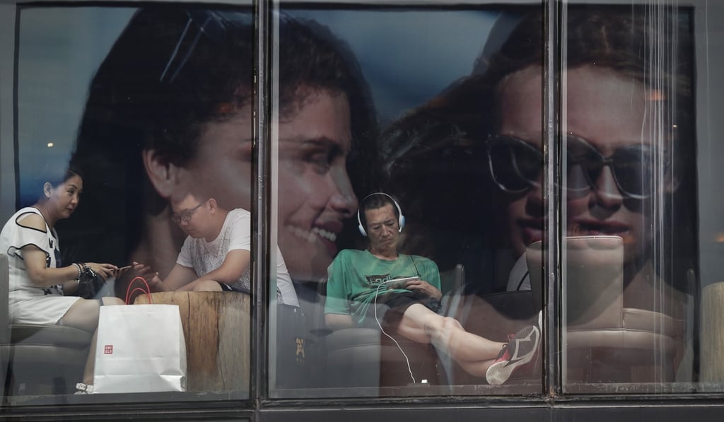 People in Beijing spend time at a cafe in July 2017. As recently as the 1980s, consumer credit was unheard of in China. But it has surged to make up 36 per cent of banking assets. Photo: AP