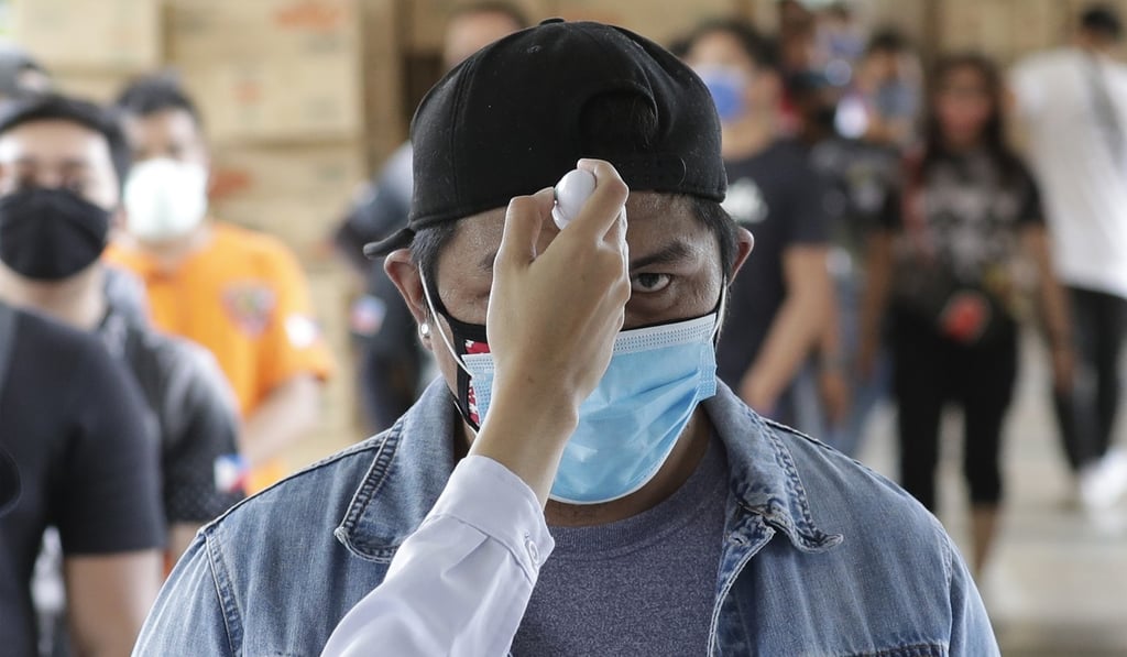 Temperatures are checked before people enter a local city hall in Manila. Photo: AP
