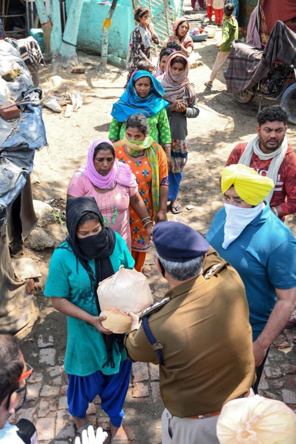Police personnel distribute free food to people in need during the first day of a 21-day government-imposed nationwide lockdown as a preventive measure against the coronavirus in Amritsar. Photo: AFP