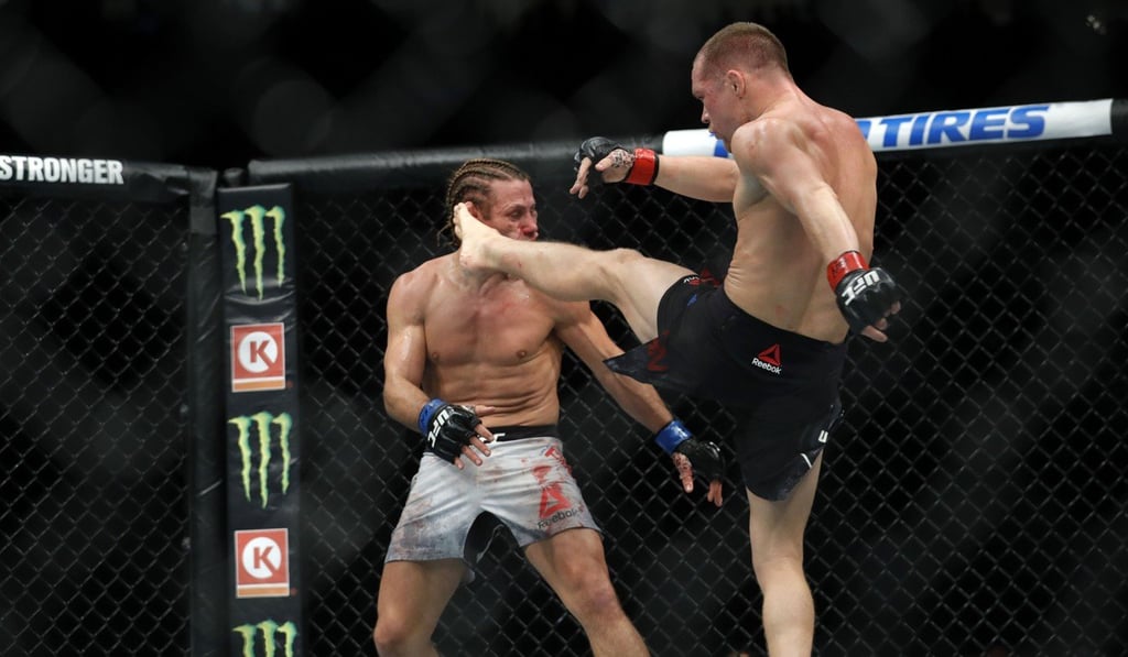 Yan lands a kick on MMA legend Urijah Faber in the third round of their bantamweight fight at UFC 245 in December 2019. Photo: AFP