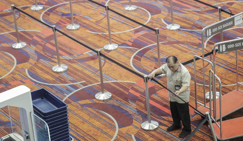 An airport worker in an empty departure hall at Changi Airport in Singapore. Photo: EPA-EFE