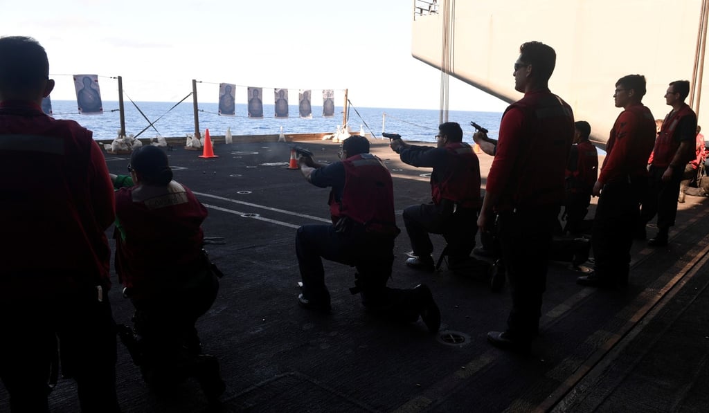 US Navy sailors participate in a small arms qualification aboard the aircraft carrier USS Theodore Roosevelt in the Philippine Sea in March. Photo: Reuters US Navy sailors participate in a small arms qualification aboard the aircraft carrier USS Theodore Roosevelt in the Philippine Sea in March. Photo: Reuters