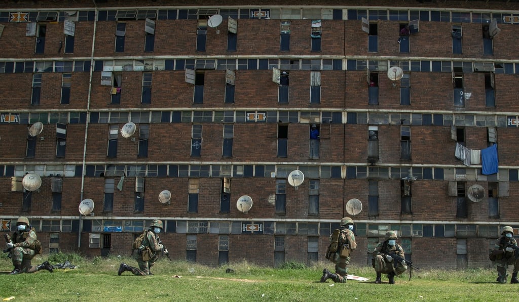 South African National Defence Forces take up positions outside a hostel in a densely populated Alexandra township east of Johannesburg, South Africa. Photo: AP