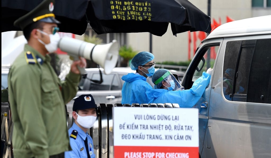 Health workers check temperatures of visitors at the entrance of Bach Mai hospital in Hanoi last Tuesday. Photo; AFP