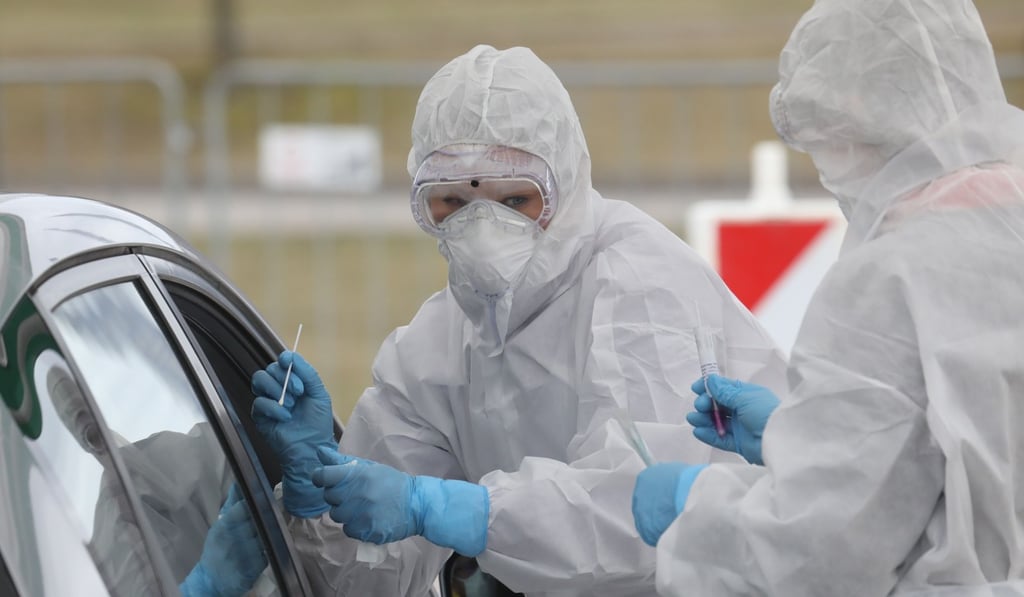 Medical workers take samples from car passengers at a drive-through coronavirus testing point in Vilnius, Lithuania. Photo: AFP Medical workers take samples from car passengers at a drive-through coronavirus testing point in Vilnius, Lithuania. Photo: AFP