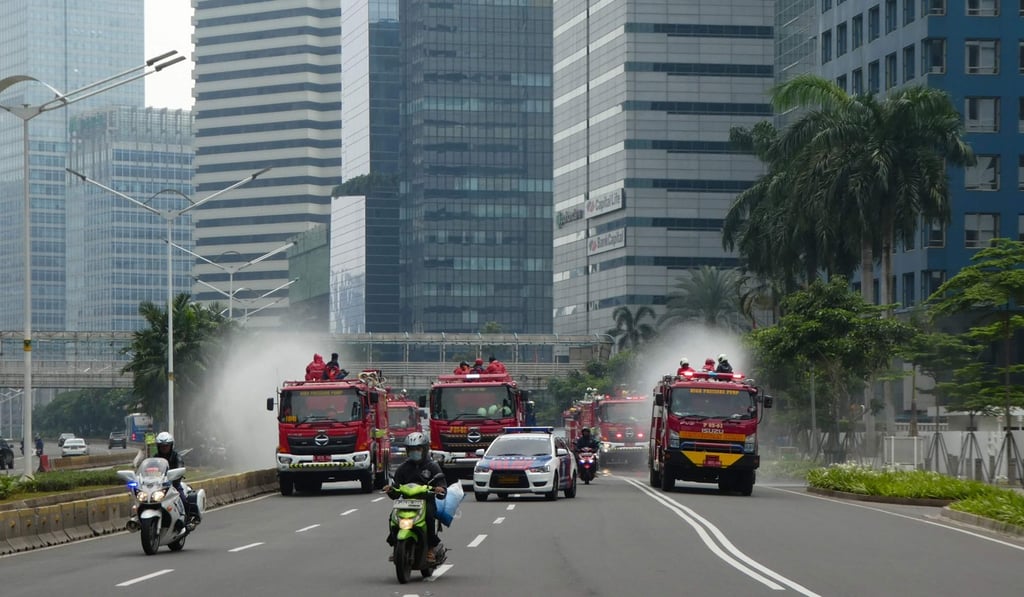 Firefighters spray disinfectant on a road in downtown Jakarta. The country has resisted calls to impose a lockdown, despite a spike in coronavirus cases. Photo: AFP Firefighters spray disinfectant on a road in downtown Jakarta. The country has resisted calls to impose a lockdown, despite a spike in coronavirus cases. Photo: AFP