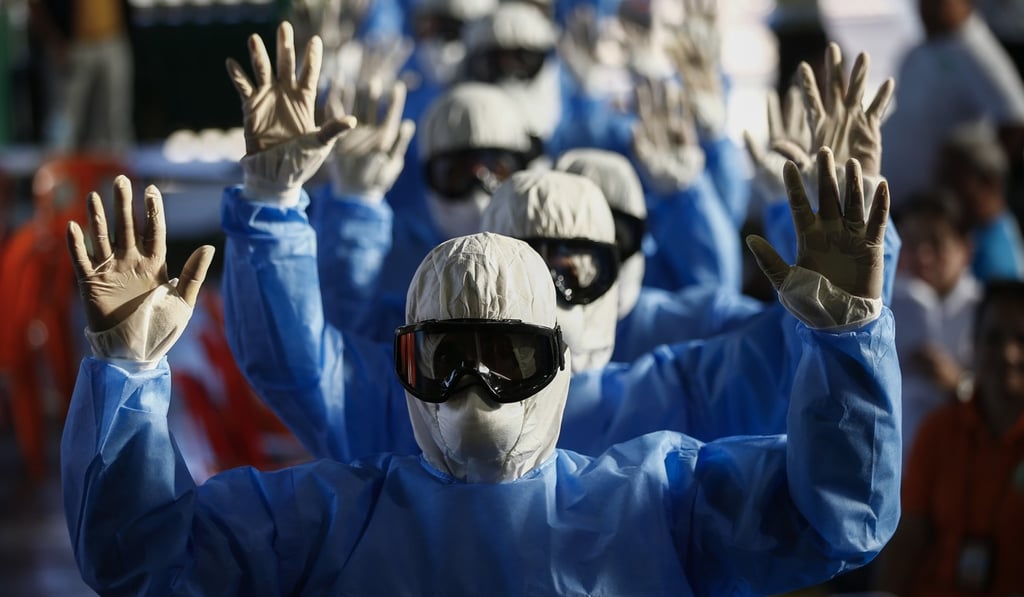 Village emergency response teams undergo training in using protective suits when responding to potential Covid-19 cases at a gymnasium in Quezon City, Metro Manila, Philippines, on March 13. Photo: EPA-EFE