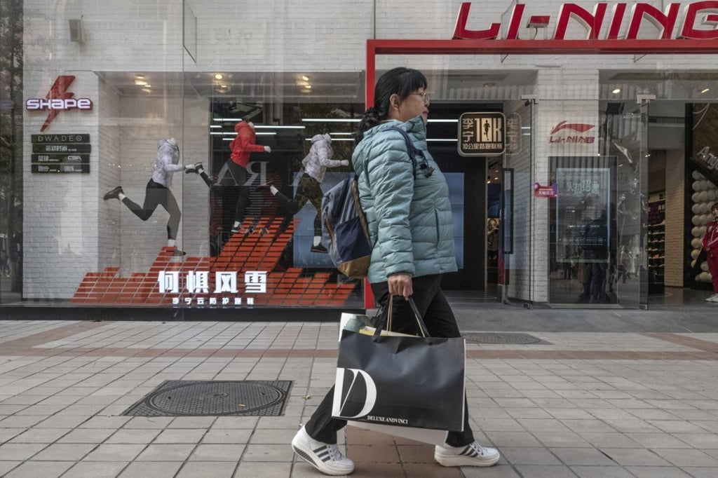 A shopper walks past a store on Wangfujing Street in Beijing on November 3, 2018. As demand from Europe and the US dries up, the government must boost domestic consumption. Photo: Bloomberg