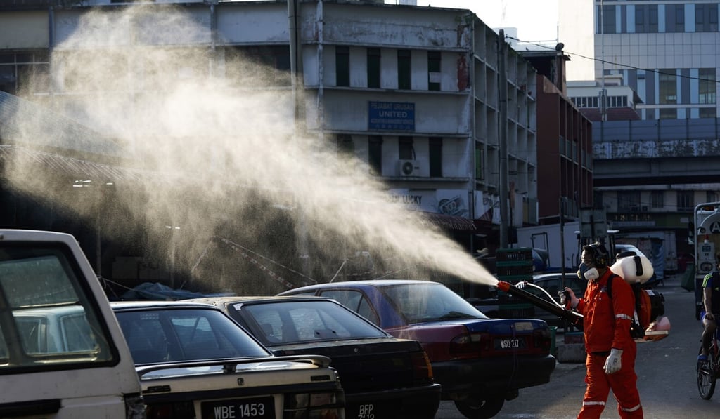 A City Hall health official sprays disinfectant at a wet market in Kuala Lumpur, Malaysia. Photo: AP A City Hall health official sprays disinfectant at a wet market in Kuala Lumpur, Malaysia. Photo: AP