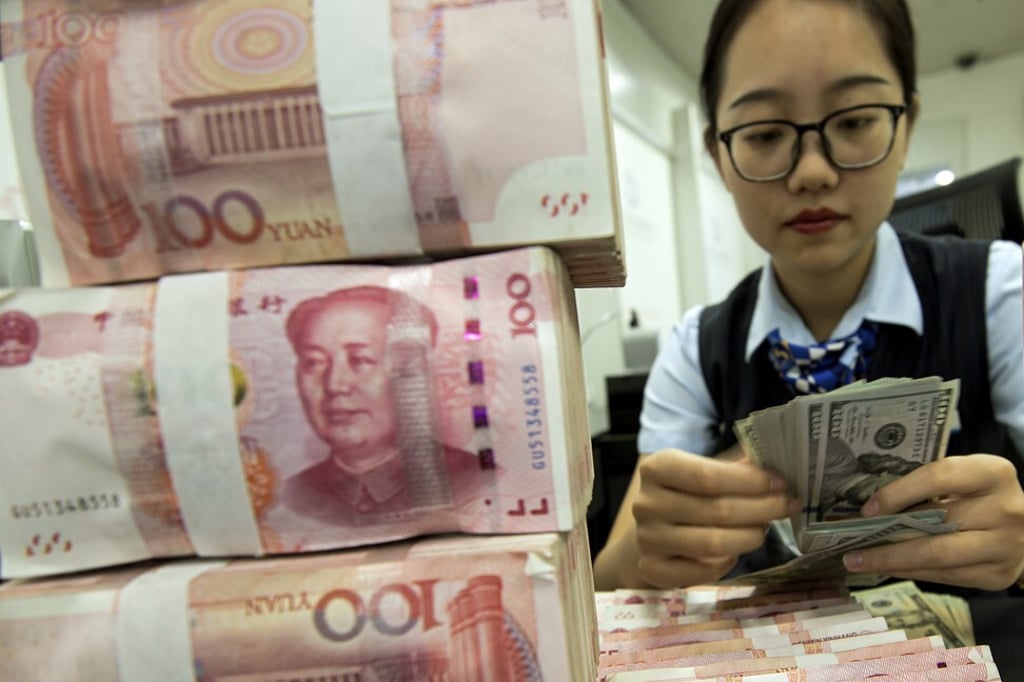 A bank employee counts US dollar banknotes next to a stack of Chinese yuan at a branch in Jiangsu province, in August last year. Amid the global US dollar shortage, the renminbi has held up exceptionally well compared with other emerging-market currencies. Photo: Chinatopix via AP