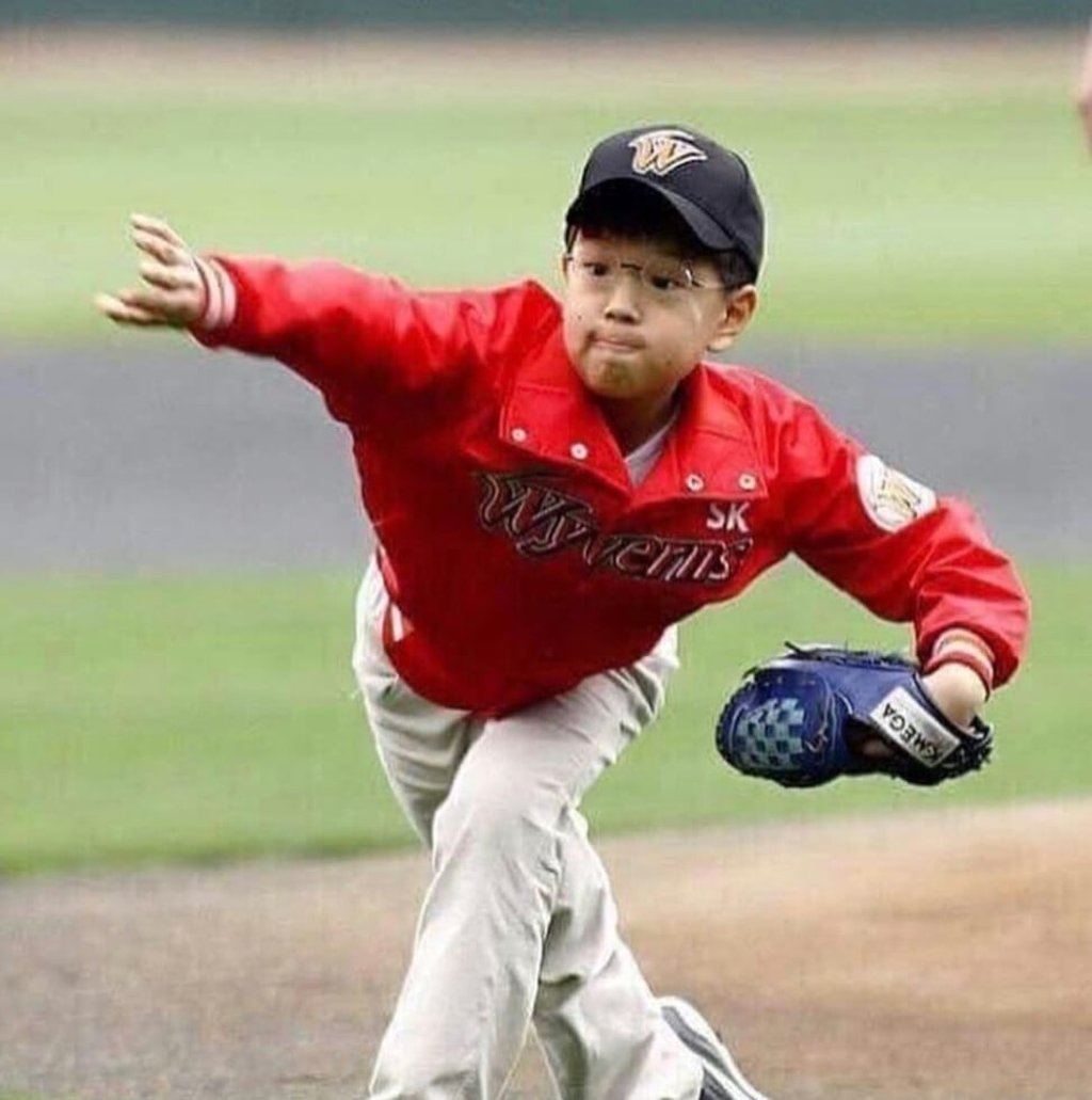 A young Seungmin pitching a baseball at a game. A young Seungmin pitching a baseball at a game.