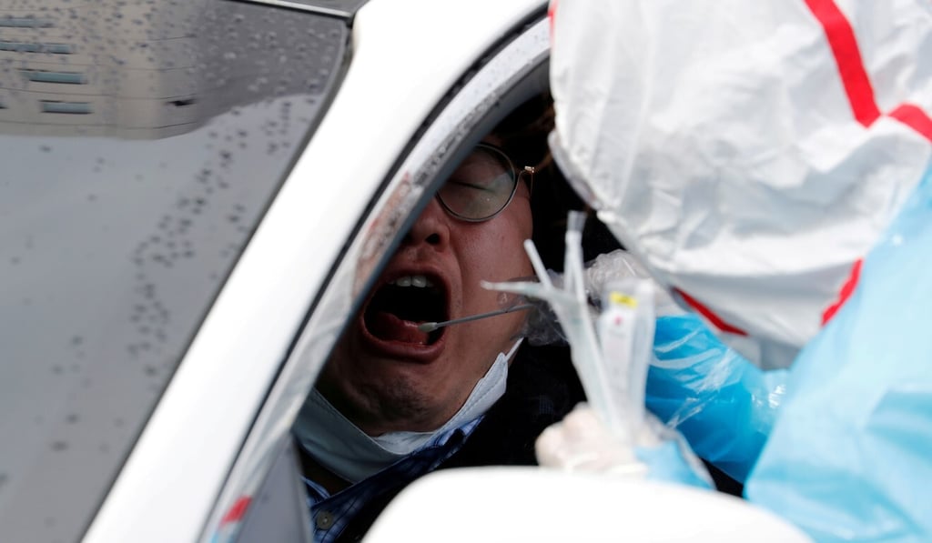 A man has a swab taken at a ‘drive though’ testing centre in South Korea, which has been lauded for its handling of the pandemic. Photo: Reuters A man has a swab taken at a ‘drive though’ testing centre in South Korea, which has been lauded for its handling of the pandemic. Photo: Reuters