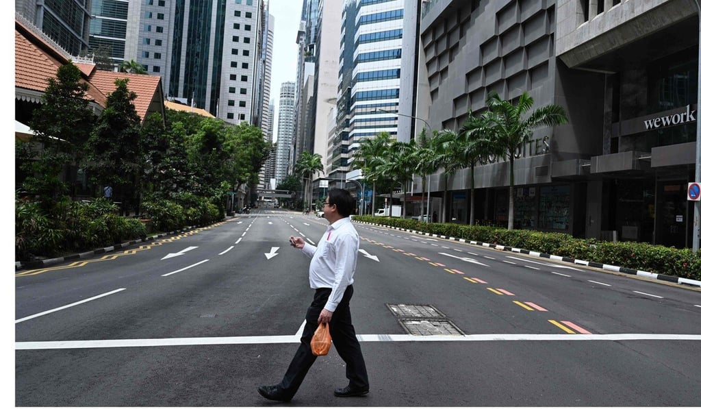 A man crosses an empty street in the central business district of Singapore. Photo: AFP A man crosses an empty street in the central business district of Singapore. Photo: AFP