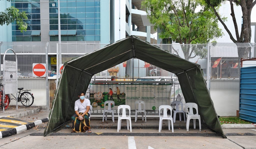 A migrant worker waits to get a medical check near the Toh Guan Dormitory in Singapore on April 8. Photo: Xinhua A migrant worker waits to get a medical check near the Toh Guan Dormitory in Singapore on April 8. Photo: Xinhua