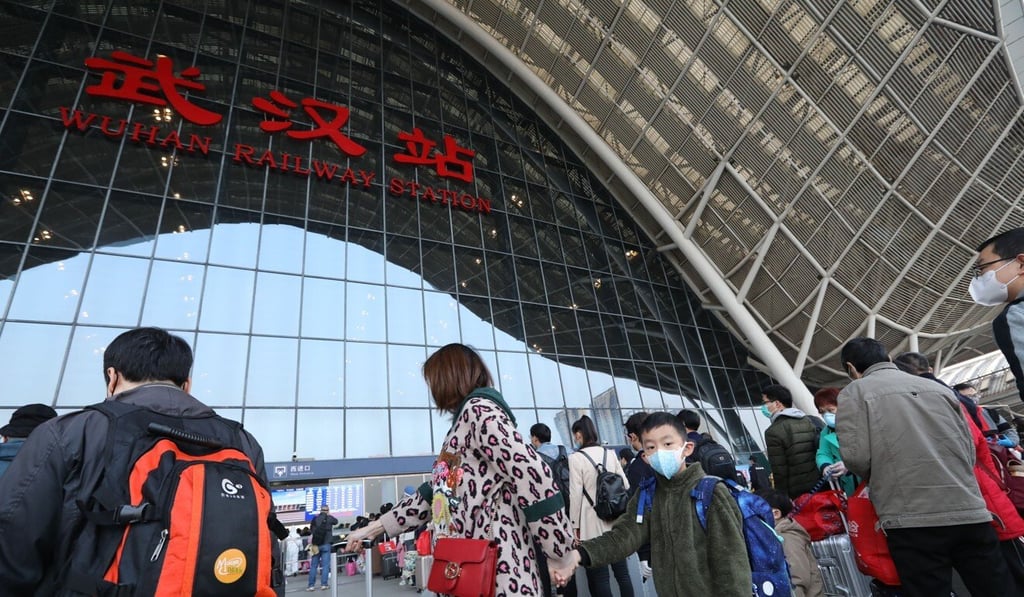Passengers line up to enter Wuhan Railway Station to leave the city on Wednesday morning. Photo: Simon Song