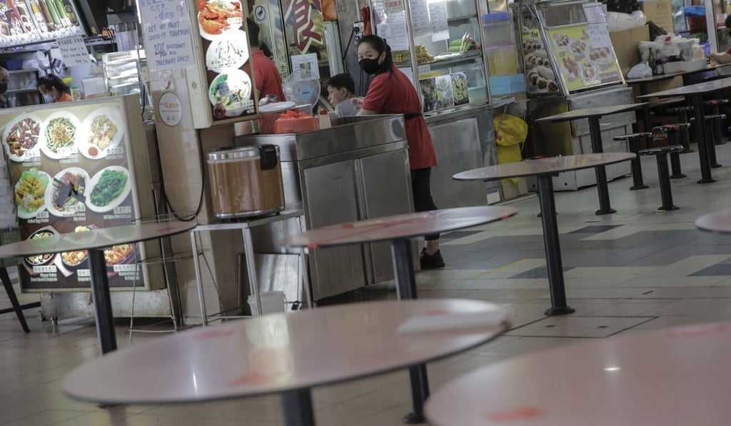Staff wait for customers at an empty food court in Singapore on Tuesday. Photo: EPA