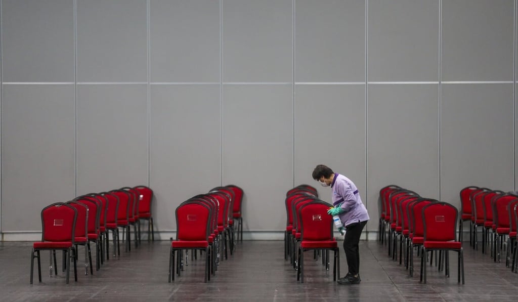 A worker cleans chairs in the coronavirus testing centre at AsiaWorld-Expo. Photo: Winson Wong
