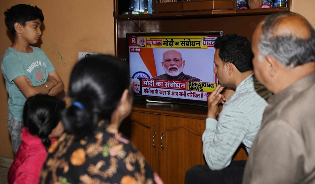 A family watches Indian Prime Minister Narendra Modi's address to the nation on the coronavirus lockdown. Photo: AFP