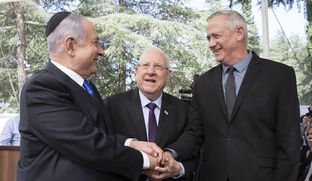 Israeli Prime Minister Benjamin Netanyahu (L), Israeli President Reuven Rivlin (C) and Benny Gantz, former Israeli Army Chief of Staff and chairman of the Blue and White Israeli centrist political alliance (R) join hands as they attend a memorial service for late Israeli president Shimon Peres. Photo: EPA-EFE