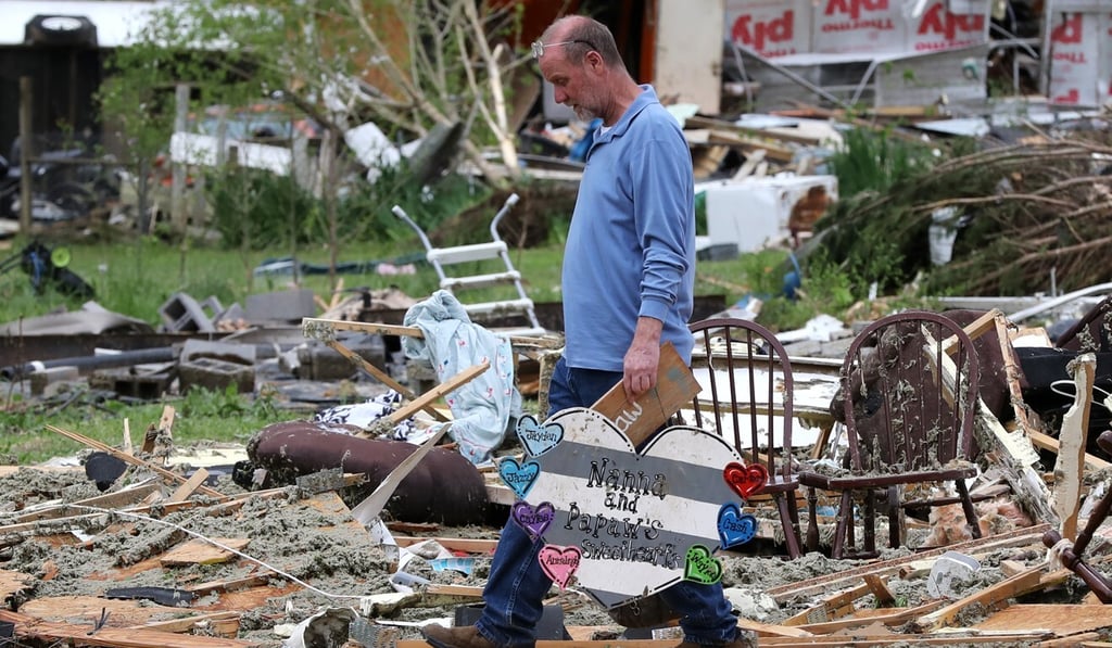 A man salvages a heart-shaped sign with the names of his grandchildren from the rubble of his trailer in Chatsworth, Georgia, on Monday. Photo: dpa A man salvages a heart-shaped sign with the names of his grandchildren from the rubble of his trailer in Chatsworth, Georgia, on Monday. Photo: dpa