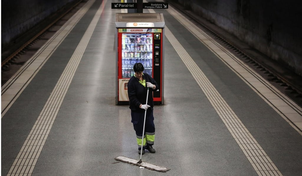 A municipal cleaner sweeps a deserted train platform as commuters stay home because of the coronavirus outbreak. Photo: Bloomberg