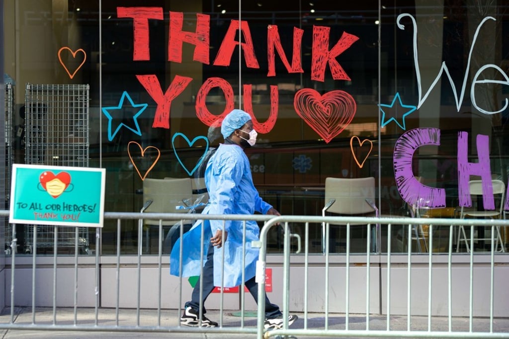 A Montefiore Medical Centre employee walks past signs thanking the medical staff on April 9 in New York. The city has recorded over 10,000 deaths, with medical staff struggling with a shortage of protective gear. Photo: AFP