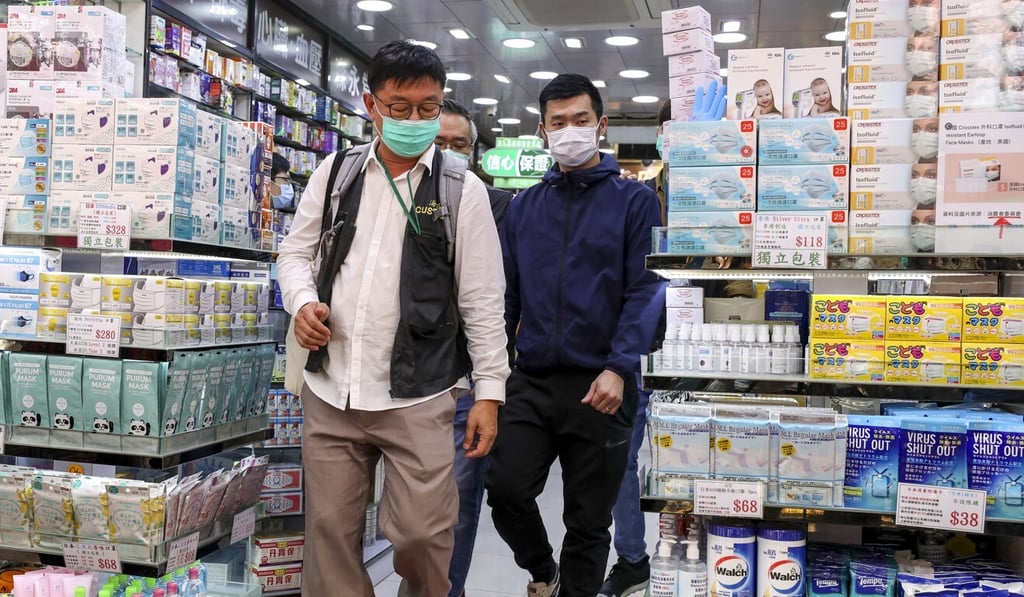 A customs officer (left) with one of the suspects at Wing Lee Dispensary in Lockhart Road in Causeway Bay. Photo: Nora Tam