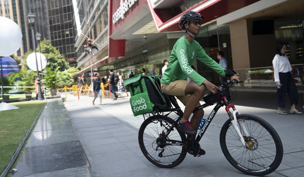 A rider for the GrabFood online food-delivery platform cycles outside Raffles Place in Singapore last year. Photo: Bloomberg