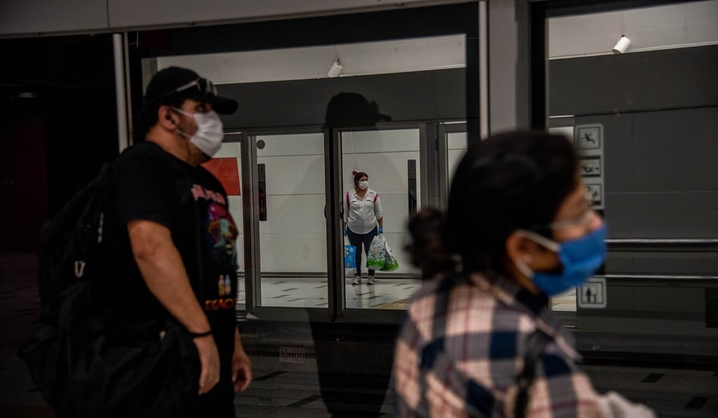 People wearing protective masks wait for a train at the Plaza de Armas subway station in Santiago, Chile. Photo: Bloomberg