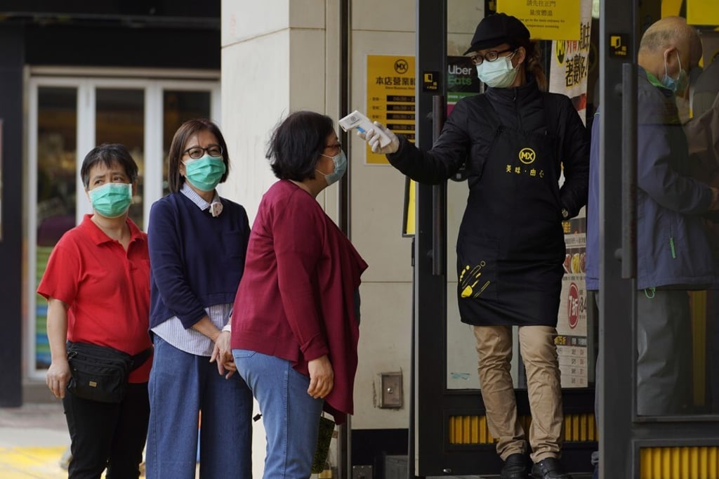 Customers have their temperature checked at a restaurant in Hong Kong. Photo: AP