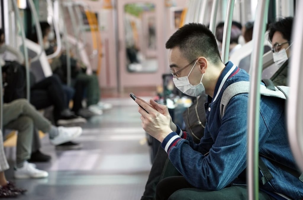 A man wearing a face mask sits in a train in Tokyo, Japan. Photo: EPA