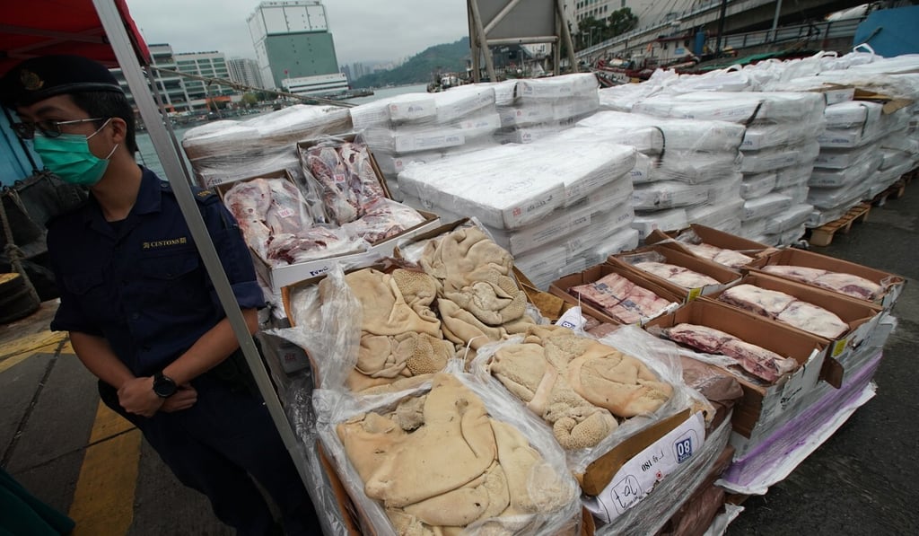 Customs officers display the frozen meat in Chai Wan. Photo: Felix Wong