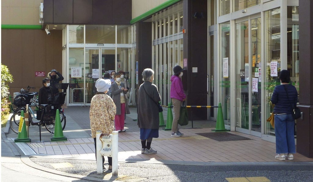 People observe social distancing in front of a supermarket in Tokyo. Photo: Kyodo People observe social distancing in front of a supermarket in Tokyo. Photo: Kyodo