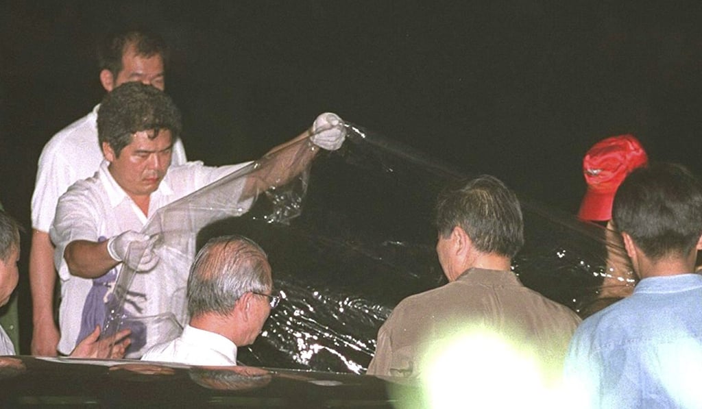 A policeman lifts up a plastic sheet draped over the body of Pai Hsiao-yen. Photo: AFP A policeman lifts up a plastic sheet draped over the body of Pai Hsiao-yen. Photo: AFP