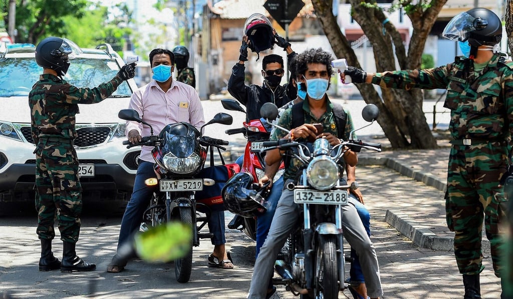 Security personnel check the body temperature of motorists at a checkpoint in Sri Lanka. Photo: AFP Security personnel check the body temperature of motorists at a checkpoint in Sri Lanka. Photo: AFP