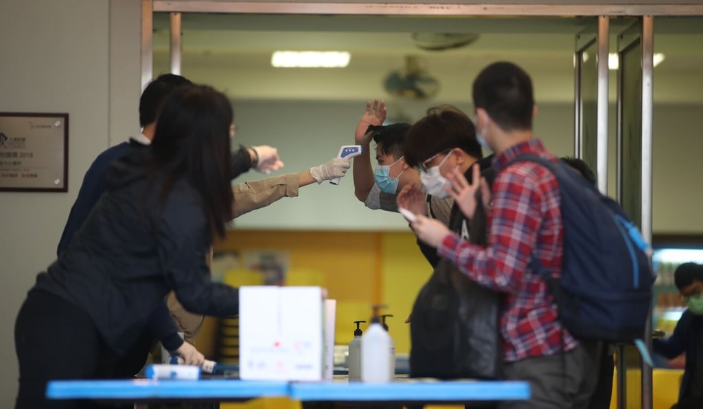 Students have their temperature checked before they enter True Light Girls’ College in Yau Ma Tei. Photo: Winson Wong
