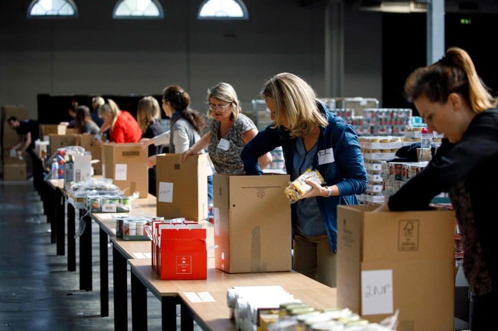 Volunteers pack food into boxes for people in need at a temporary food bank in London on April 22, 2020. Photo: AFP
