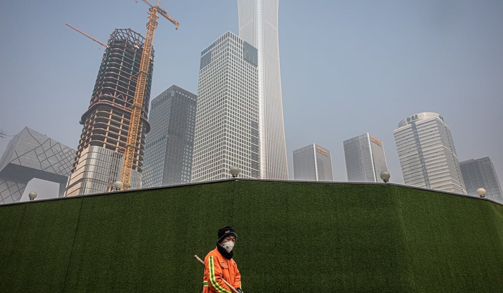 A municipal worker walks past a construction site in Beijing’s central business district on February 11. China has seen a steep decline in real estate transactions in the first quarter of 2020. Photo: EPA-EFE