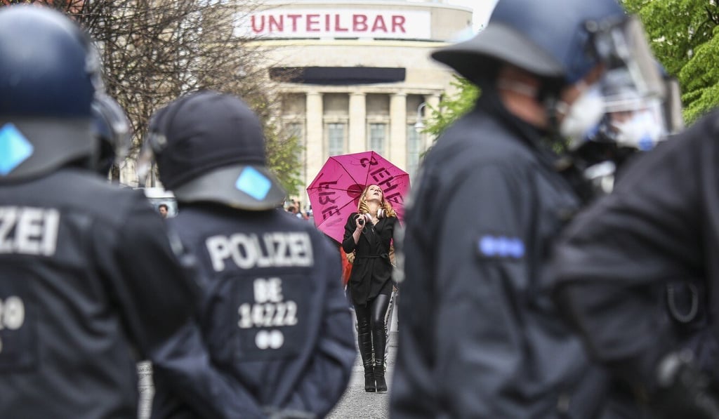 A demonstrator holds a pink umbrella at Rosa-Luxemburg-Platz square in Berlin, Germany. Photo: EPA A demonstrator holds a pink umbrella at Rosa-Luxemburg-Platz square in Berlin, Germany. Photo: EPA