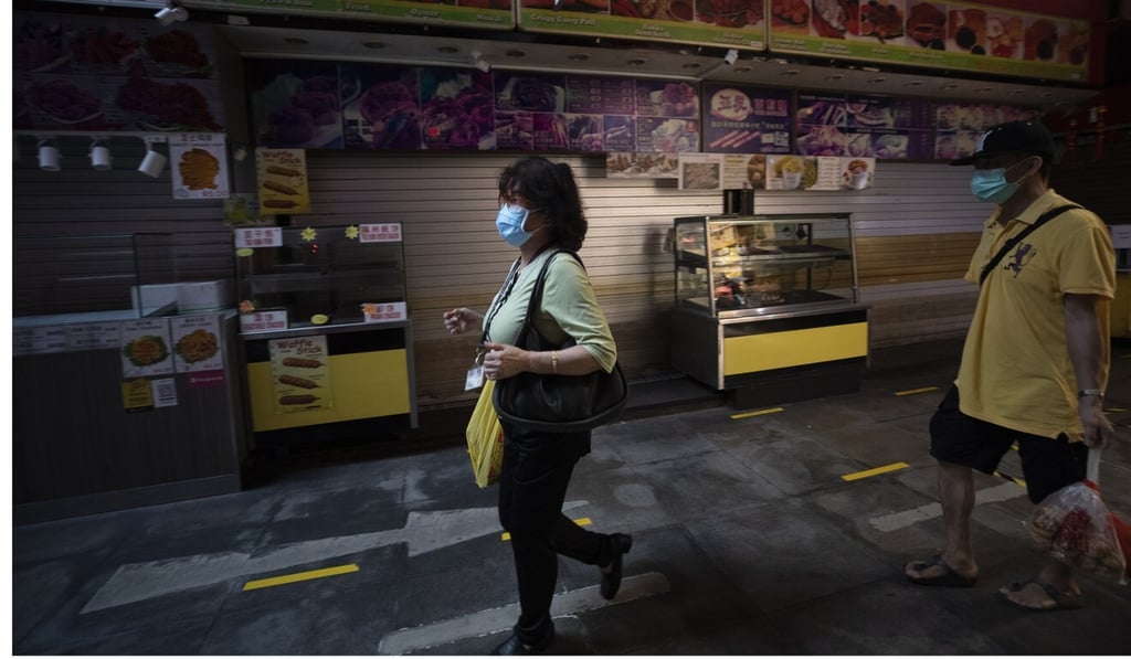 People wearing masks walk past in closed stores in Busgis street in Singapore. Photo: EPA-EFE People wearing masks walk past in closed stores in Busgis street in Singapore. Photo: EPA-EFE