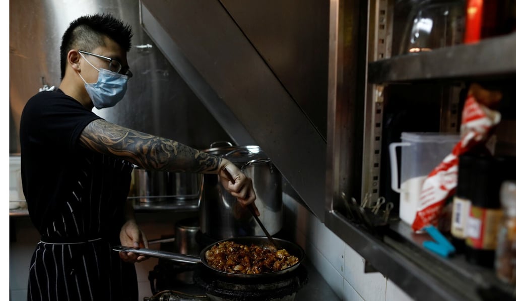 Hawker Jason Chua cooks in his stall at Hong Lim Market & Food Centre, Singapore. Photo: Reuters