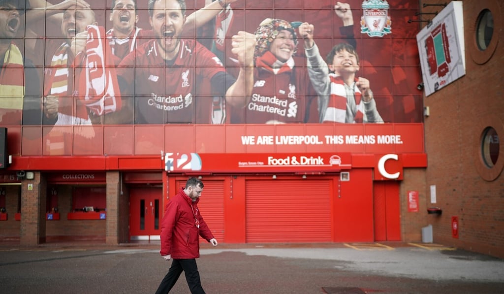 A worker walks by Anfield Stadium, the home of Liverpool Football Club. Photo: Getty Images