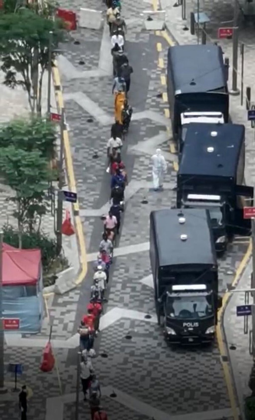 Hundreds of residents are lined up outside one of the three raided buildings. Photo: Handout