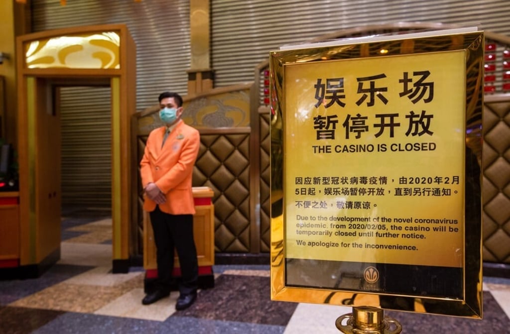 A casino staff wearing a protective mask next to a closure notice on 20 February 2020. Twenty-nine casinos reopened for gambling on 20 February, while 12 remained. Photo: EPA-EFE