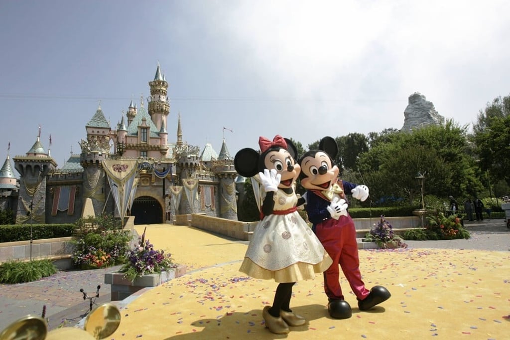 Disney characters Mickey Mouse and Minnie wave to a crowd of people in front the Sleeping Beauty Castle. Photo: AFP
