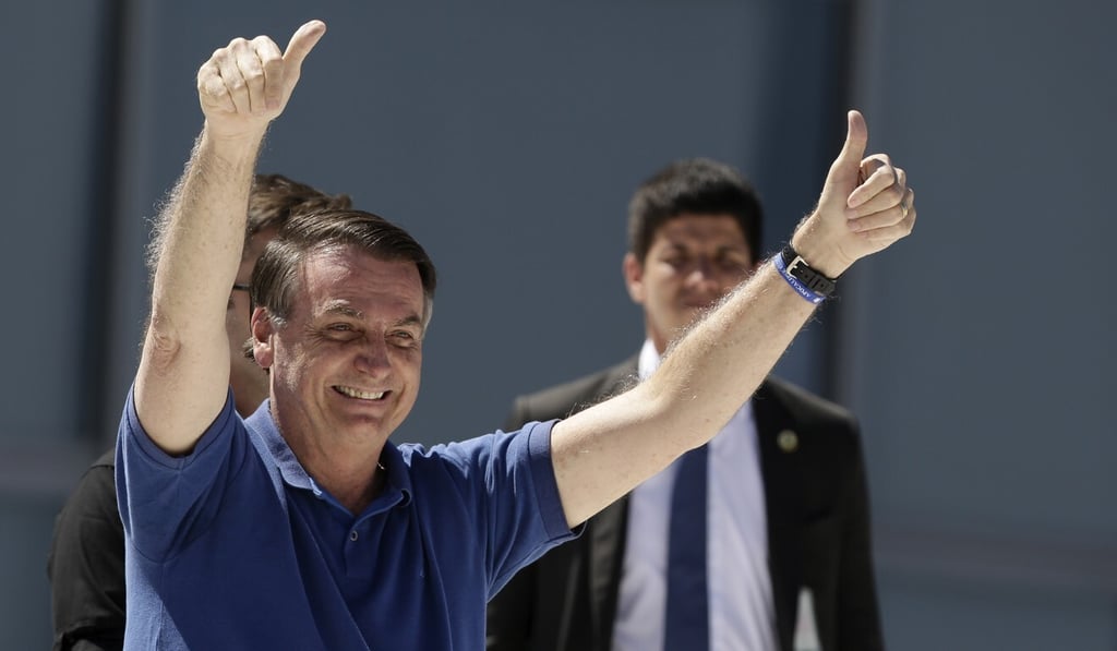 Brazil's President Jair Bolsonaro signals two thumbs-up to supporters on Sunday. Photo: AP
